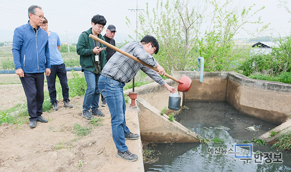 예산군청 공무원이 축산폐수를 배출한 농수로에서 시료를 채취하고 있다. ⓒ 무한정보신문