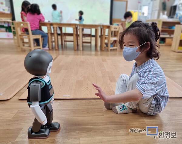 한 아이가 로봇에게 손을 보여주고 있다. ⓒ 수덕초등학교병설유치원
