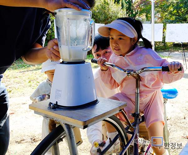 김서아 어린이가 자전거 페달을 돌려 주스를 만들고 있다. ⓒ 무한정보신문