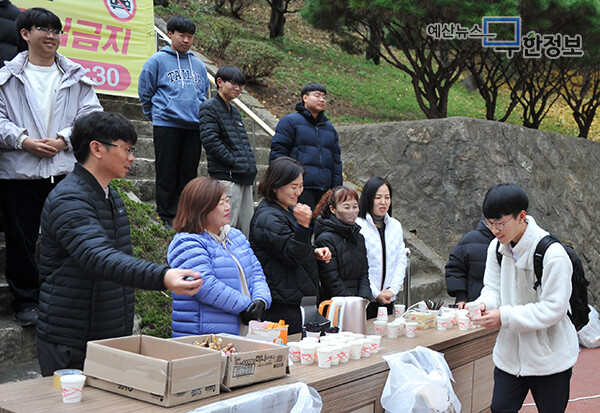 예산고등학교 교사와 학생들이 고사장으로 향하는 수험생들을 위해 따뜻한 음료를 나눠주고 있다. ⓒ 무한정보신문
